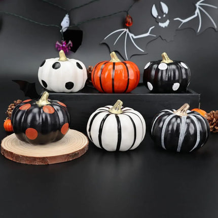 Decorative pumpkins with black, white, and orange patterns on a dark background.
