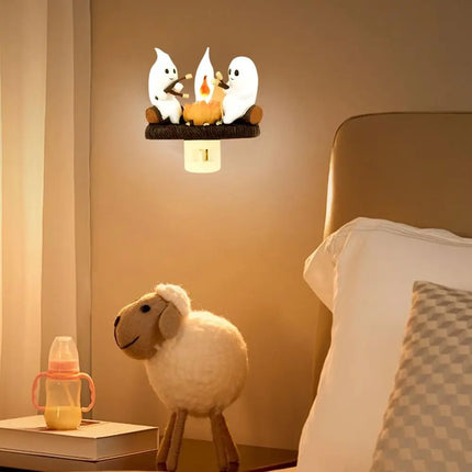 Decorative night light with cartoon characters on a wall above a bed.