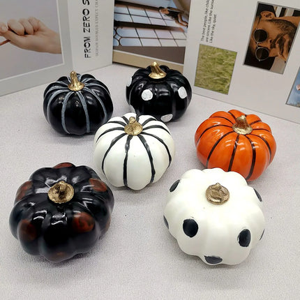 Decorative pumpkins in various colors and designs on a white surface.